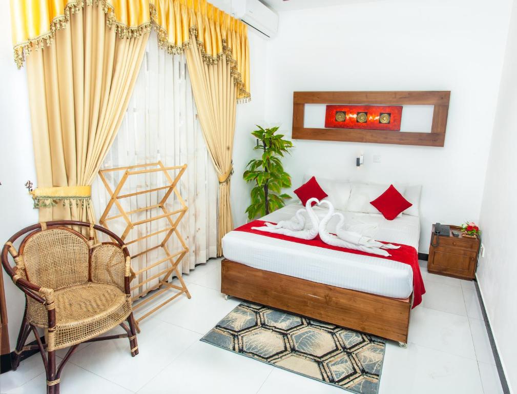可倫坡的住宿－我的假期票旅館，卧室配有床、椅子和窗户。