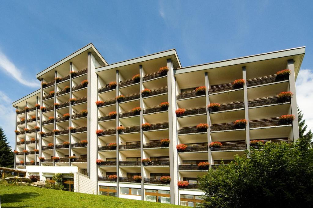 un grand immeuble avec des fleurs sur les balcons dans l'établissement Haus Bayerwald, à Neureichenau