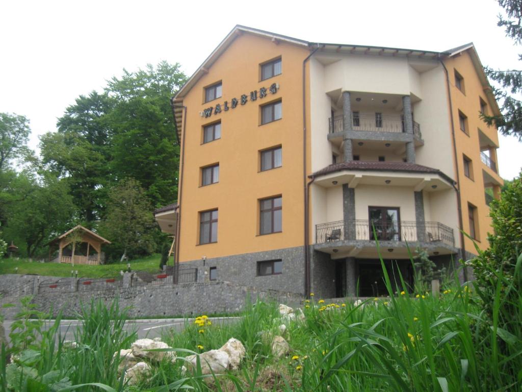 un edificio amarillo con las palabras bennington hotel en Pension Waldburg, en Râșnov