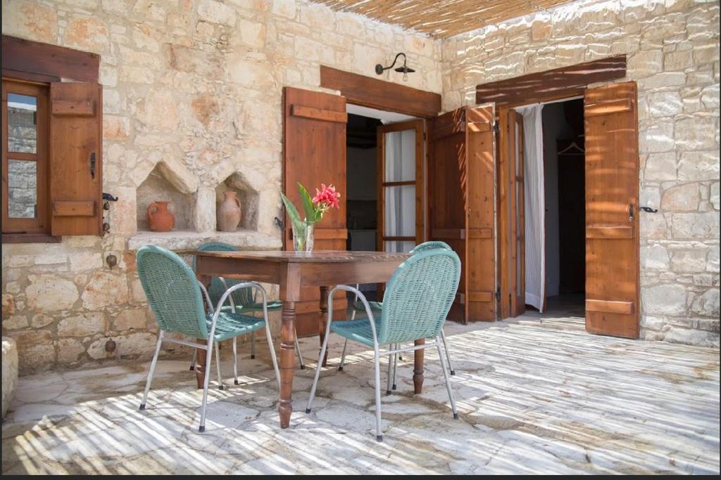 a patio with a wooden table and chairs at House of Eleni in Kathikas