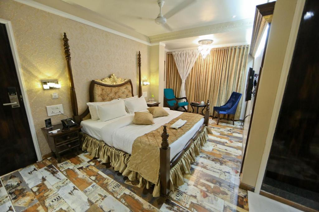 um quarto de hotel com uma cama, uma mesa e cadeiras em Hotel President em Nagpur