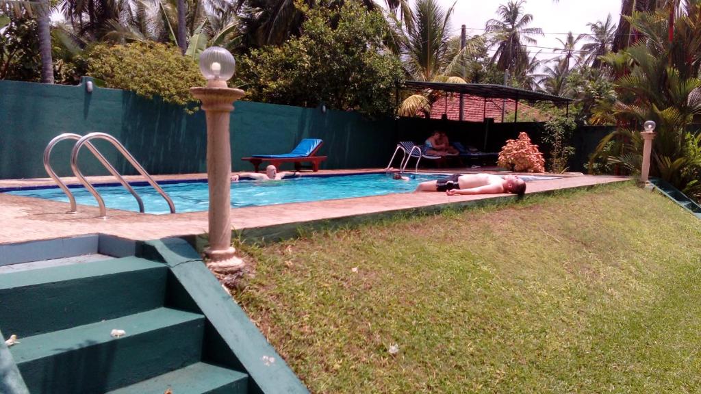 una persona está tumbada en una piscina en White Bridge House & Resort, en Aluthgama