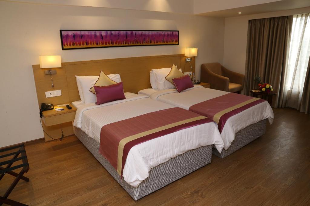 Postel nebo postele na pokoji v ubytování Sarovar Portico Rivera Ahmedabad