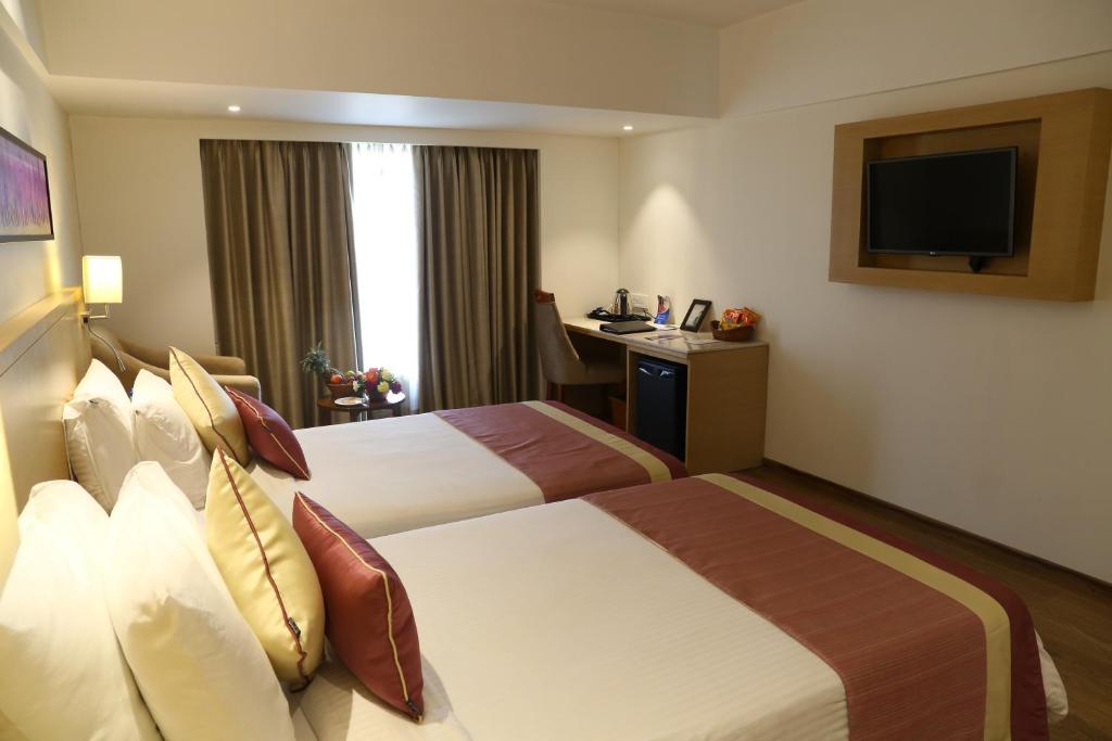 Postel nebo postele na pokoji v ubytování Sarovar Portico Rivera Ahmedabad
