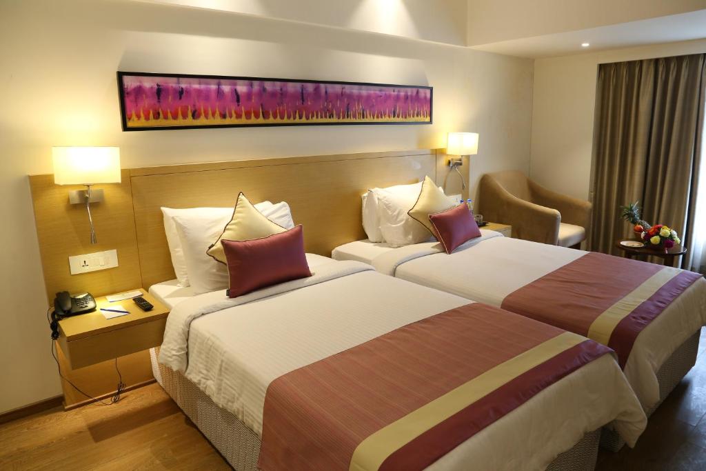 Postel nebo postele na pokoji v ubytování Sarovar Portico Rivera Ahmedabad