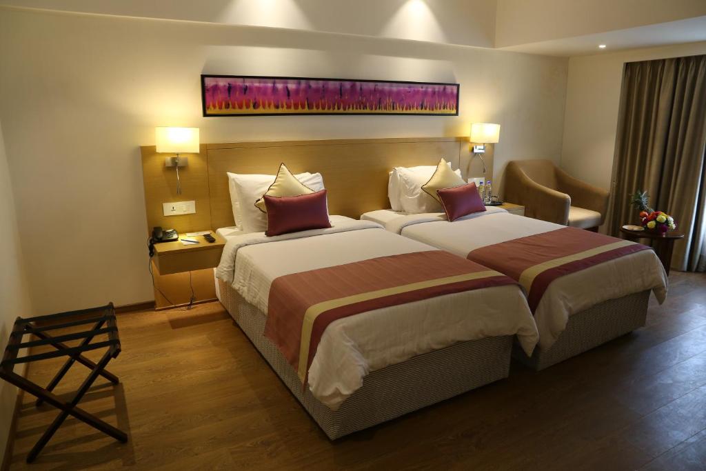Postel nebo postele na pokoji v ubytování Sarovar Portico Rivera Ahmedabad