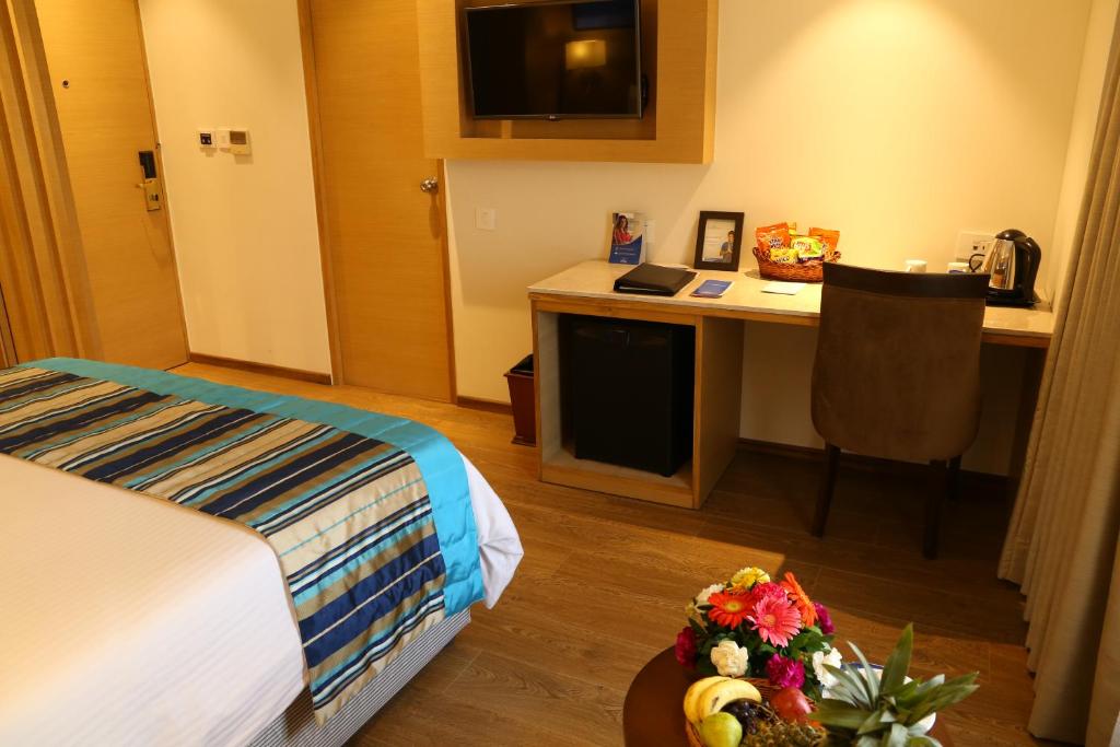 Postel nebo postele na pokoji v ubytování Sarovar Portico Rivera Ahmedabad