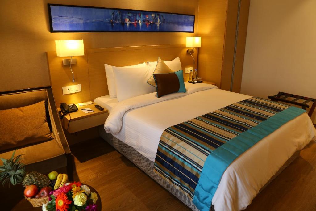Postel nebo postele na pokoji v ubytování Sarovar Portico Rivera Ahmedabad