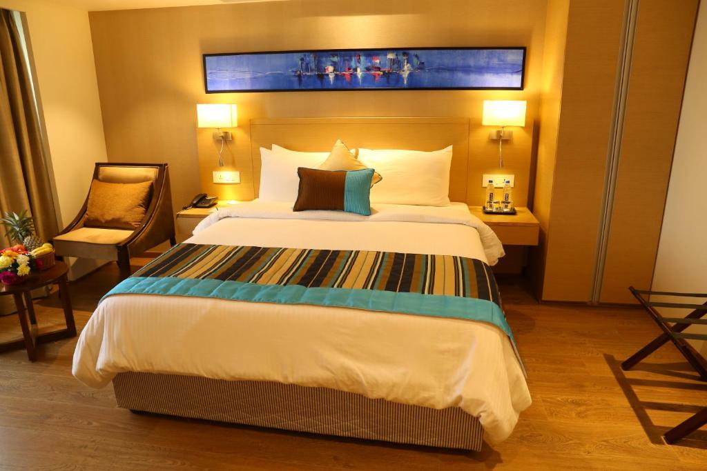 Postel nebo postele na pokoji v ubytování Sarovar Portico Rivera Ahmedabad