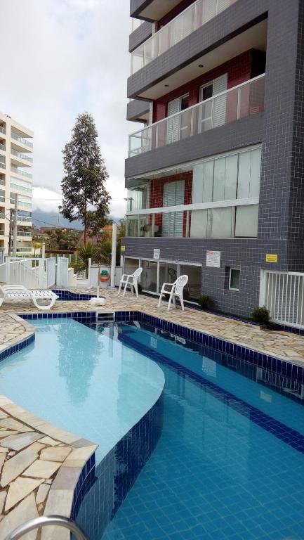 uma grande piscina em frente a um edifício em terraços do maitinga em Bertioga