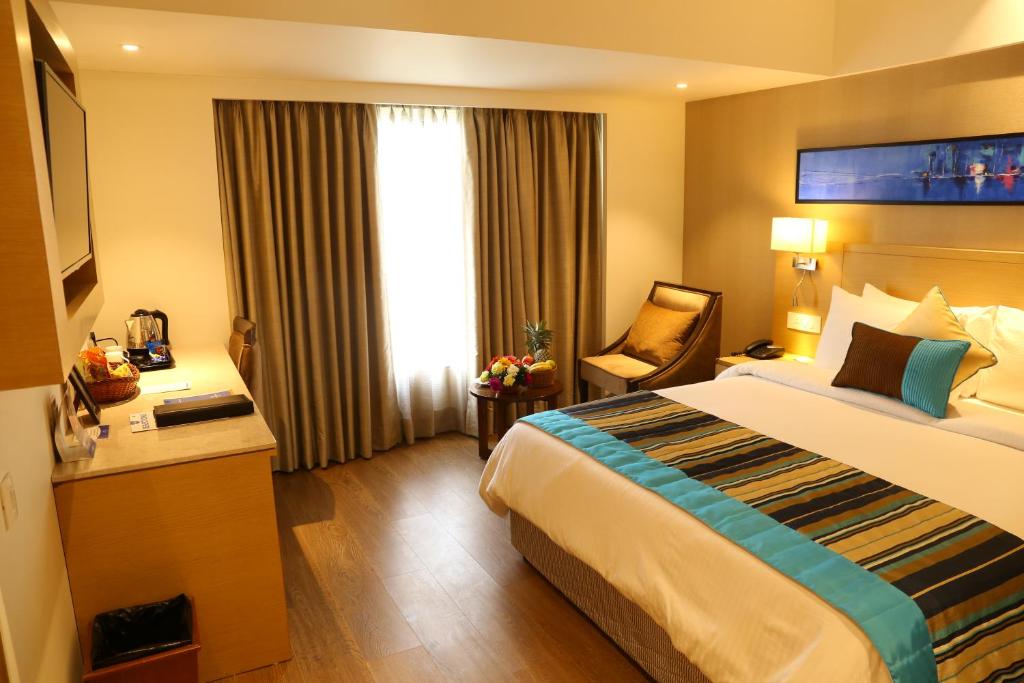Postel nebo postele na pokoji v ubytování Sarovar Portico Rivera Ahmedabad