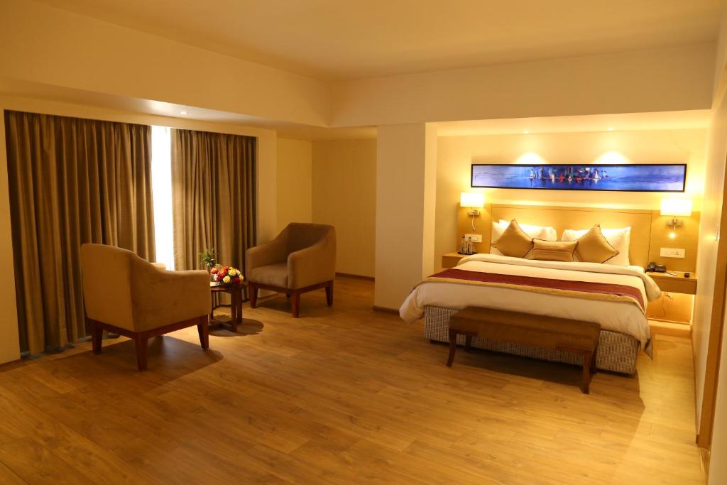 Postel nebo postele na pokoji v ubytování Sarovar Portico Rivera Ahmedabad