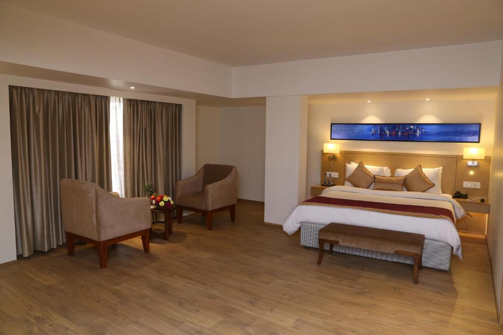Postel nebo postele na pokoji v ubytování Sarovar Portico Rivera Ahmedabad