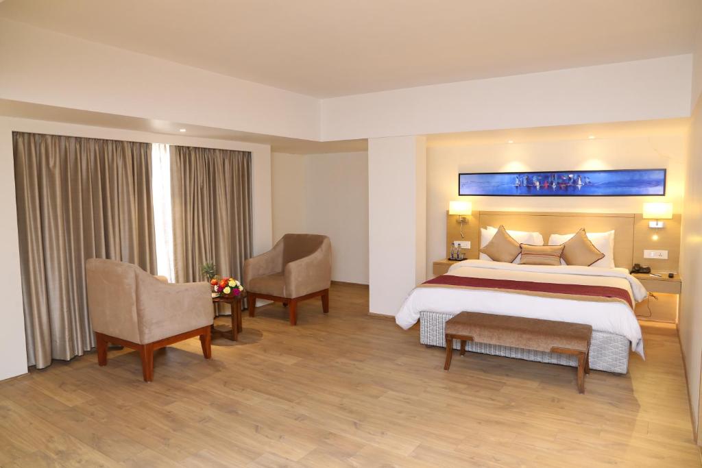 Postel nebo postele na pokoji v ubytování Sarovar Portico Rivera Ahmedabad