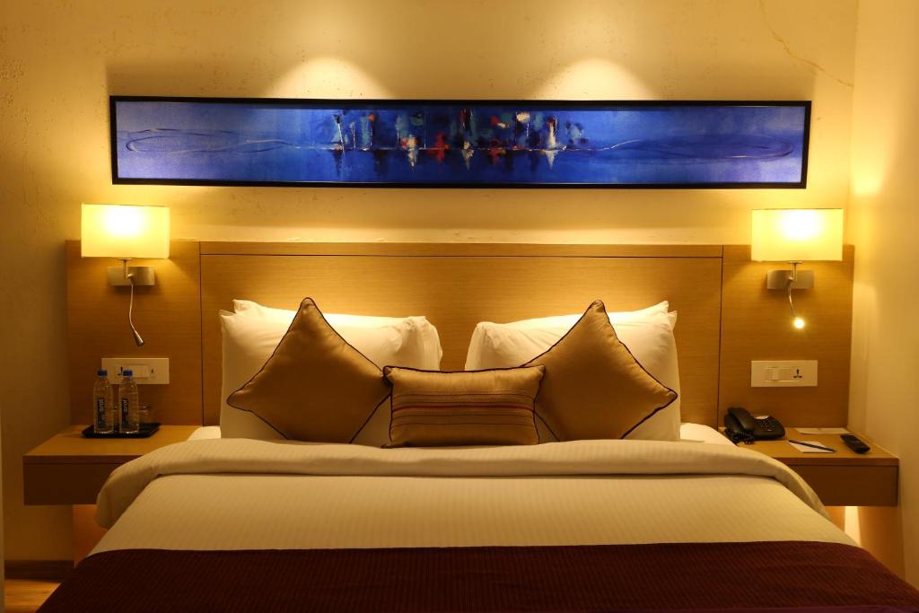Postel nebo postele na pokoji v ubytování Sarovar Portico Rivera Ahmedabad