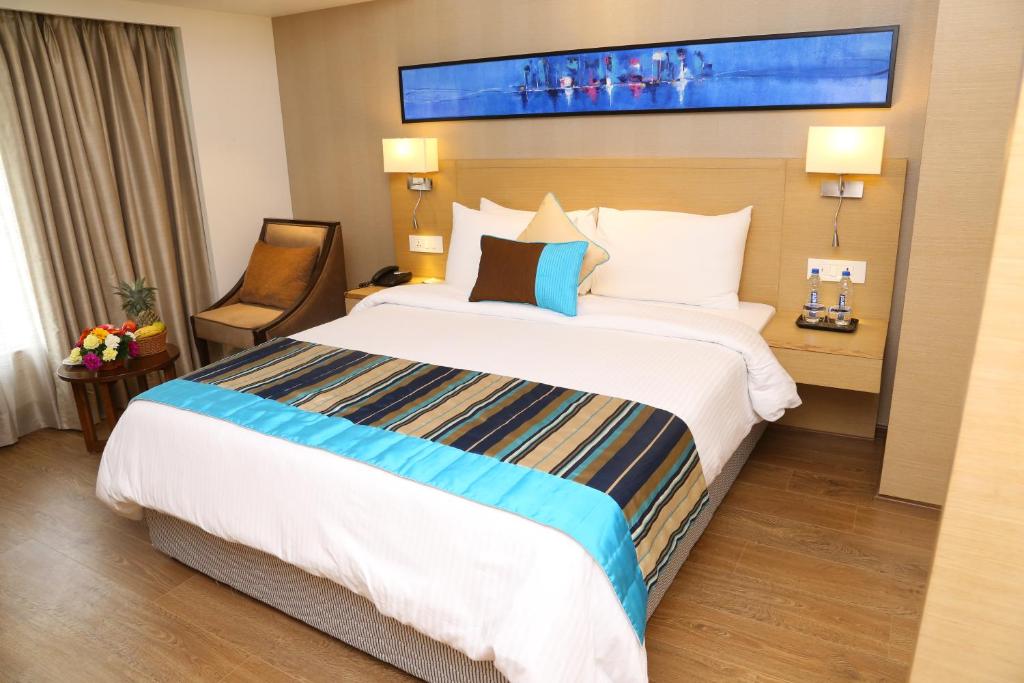 Postel nebo postele na pokoji v ubytování Sarovar Portico Rivera Ahmedabad