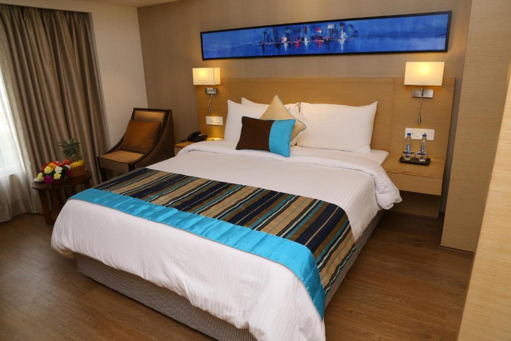 Postel nebo postele na pokoji v ubytování Sarovar Portico Rivera Ahmedabad