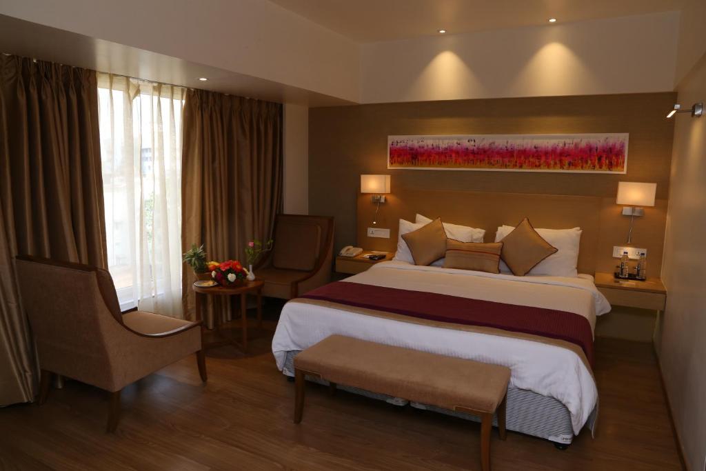 Postel nebo postele na pokoji v ubytování Sarovar Portico Rivera Ahmedabad