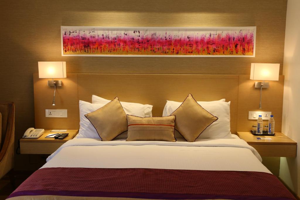 Postel nebo postele na pokoji v ubytování Sarovar Portico Rivera Ahmedabad