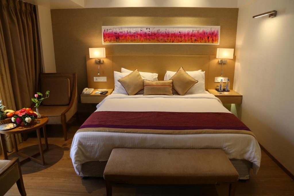 Postel nebo postele na pokoji v ubytování Sarovar Portico Rivera Ahmedabad