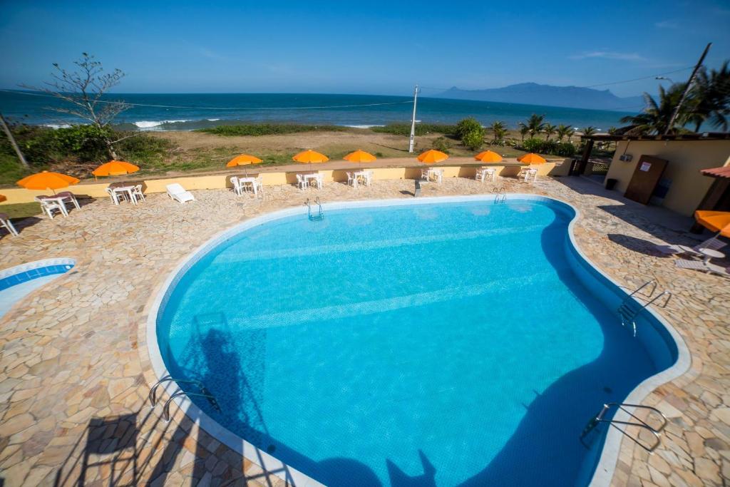 a swimming pool with a view of the ocean at Hotel Águas Vivas in Caraguatatuba