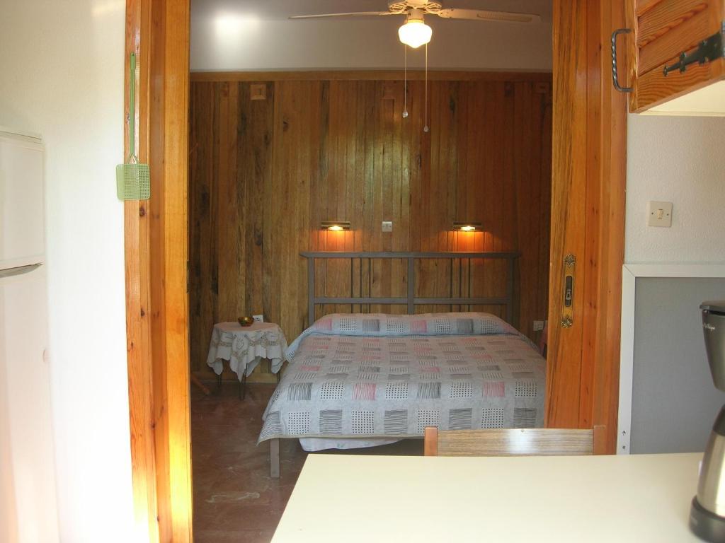 a bedroom with a bed and a table in it at Apartment Next to the Sea in Poseidonia in Posidhonía