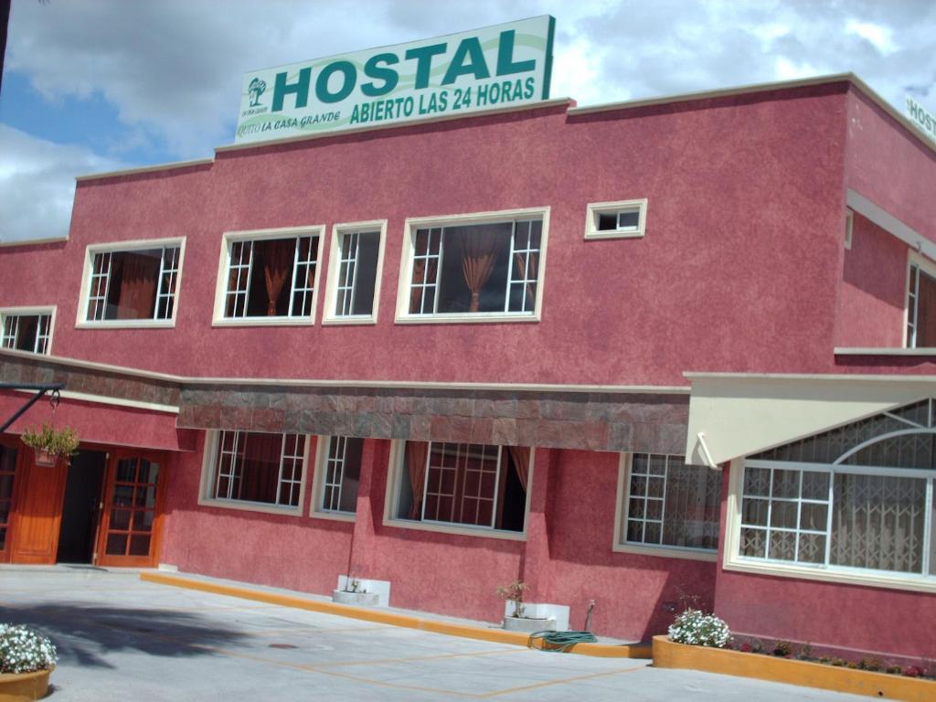 un edificio rojo con una señal de hospital en la parte superior en Hostal Casa Grande, en Quito