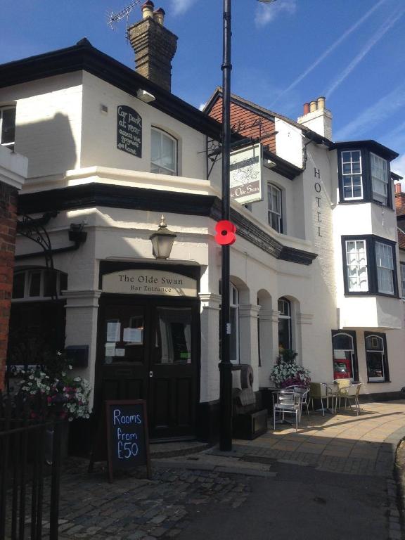 a white building with a sign in front of it at The Olde Swan Hotel in Chertsey