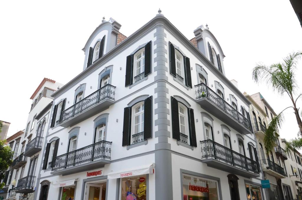 - un bâtiment blanc avec des fenêtres et des balcons noirs dans l'établissement Edificio Charles 206, à Funchal