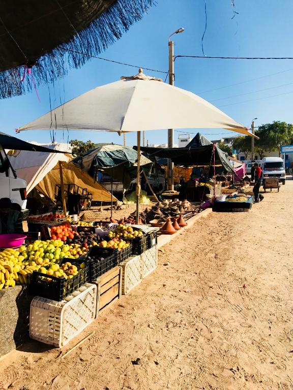 a market with fruits and vegetables on the beach at Gite Le Nomade in Mirleft