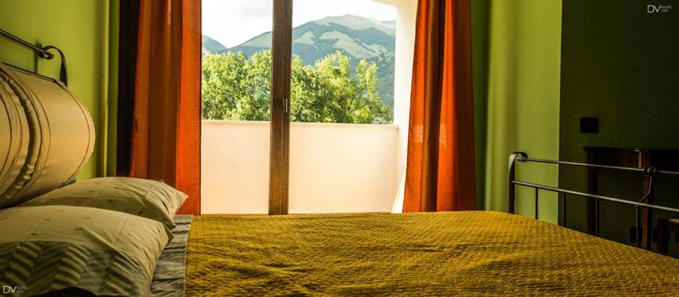a bedroom with a bed and a window with a view at Santa Giusta in Picinisco