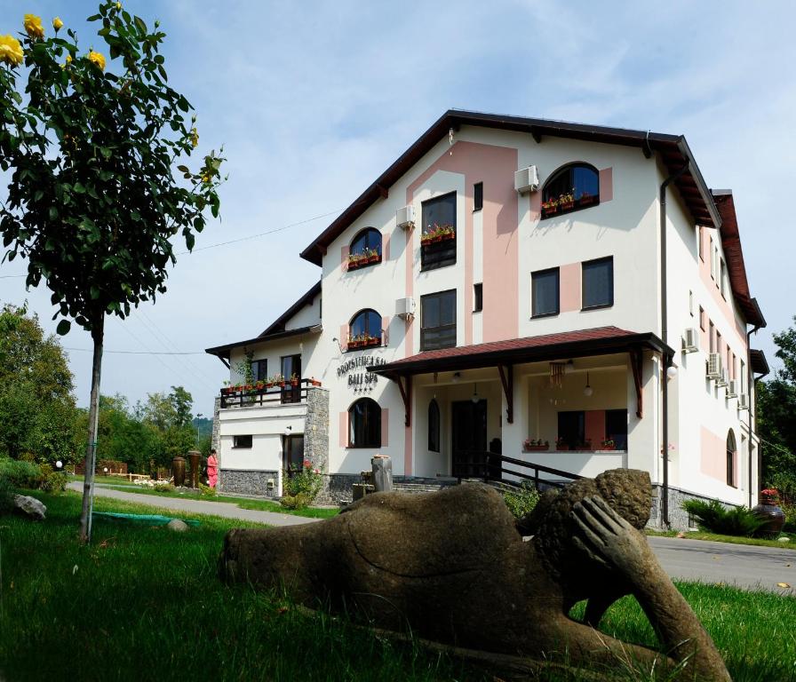 a building with a statue in front of it at Resort Bali Spa in Cornu de Jos