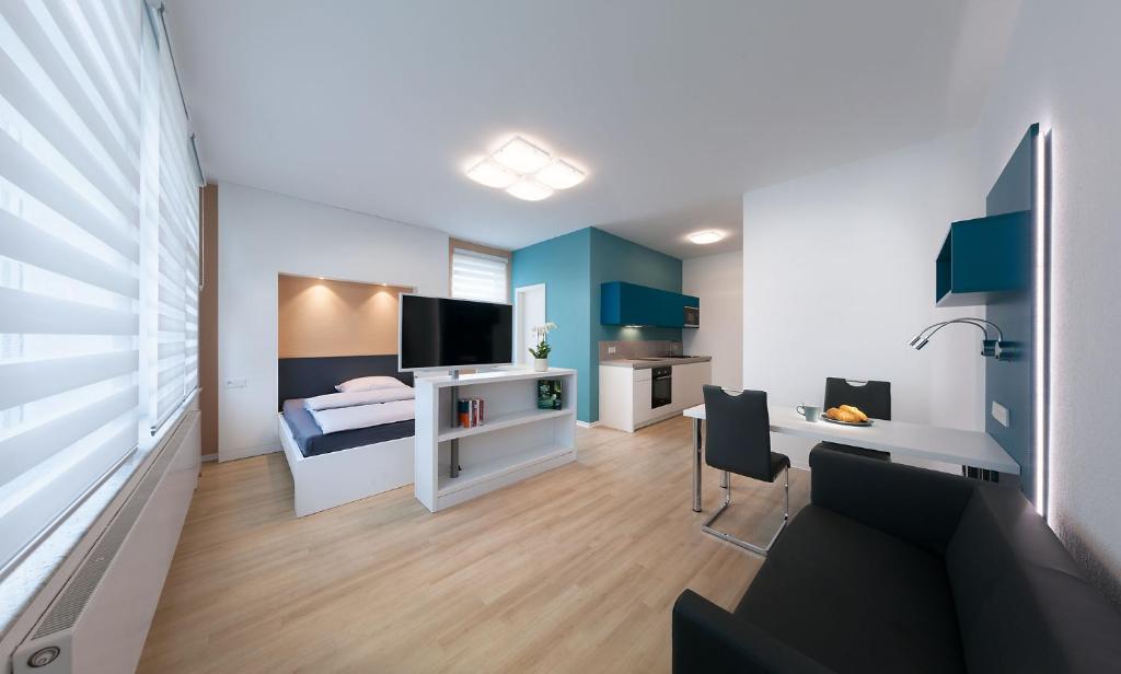 a bedroom with a bed and a desk with a television at Apartments Drei Morgen in Leinfelden-Echterdingen
