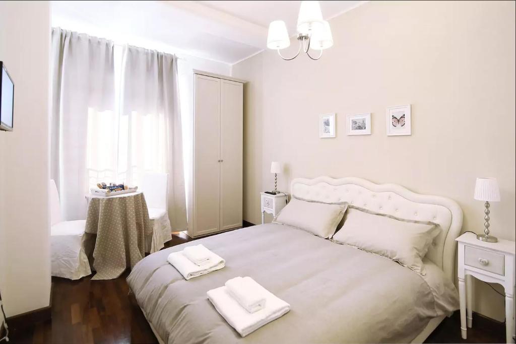 a white bedroom with a large bed with two towels on it at MC Guest House in Rome