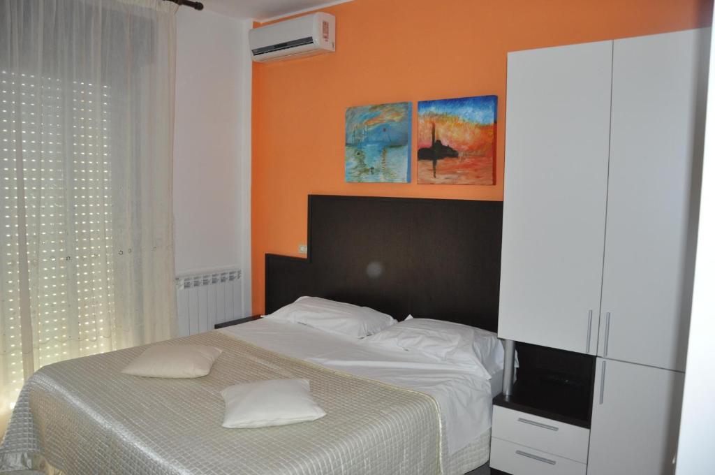 a bedroom with a bed with an orange wall at Bed & Breakfast Oasi in Pescara
