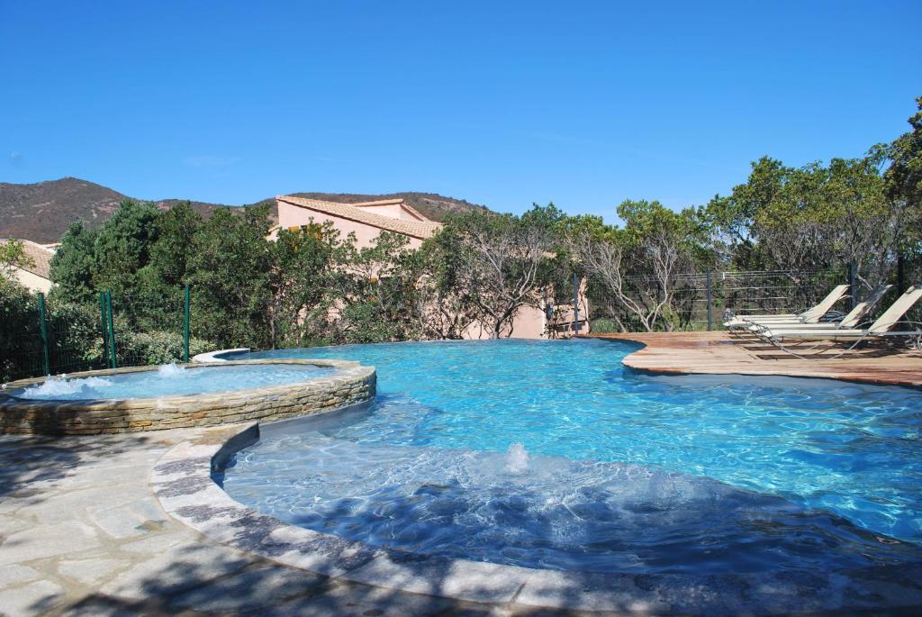 een groot zwembad met blauw water in een tuin bij L Incantu in Galeria