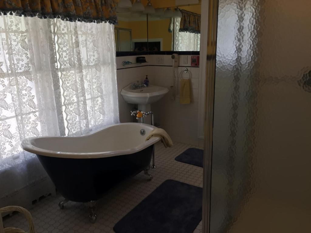 a bathroom with a bath tub and a sink at Inn at the Park in Cape May