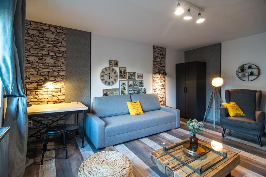クルジュ・ナポカにあるRent in Cluj Apartmentsのリビングルーム(青いソファ、テーブル付)