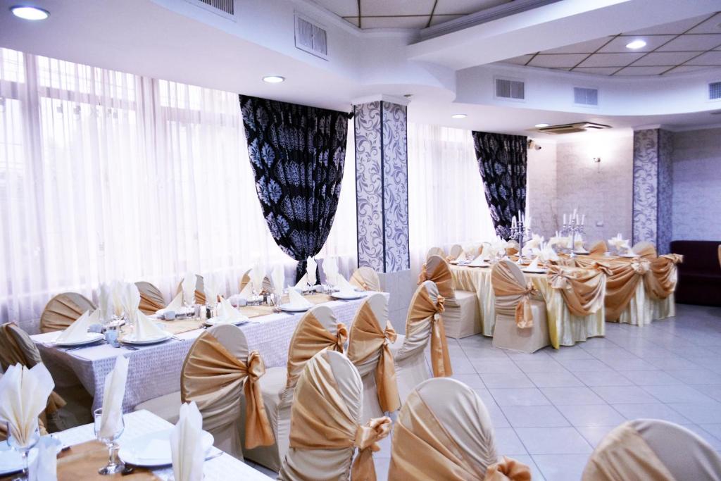 a banquet hall with white tables and chairs at Pensiunea Nicolas in Craiova