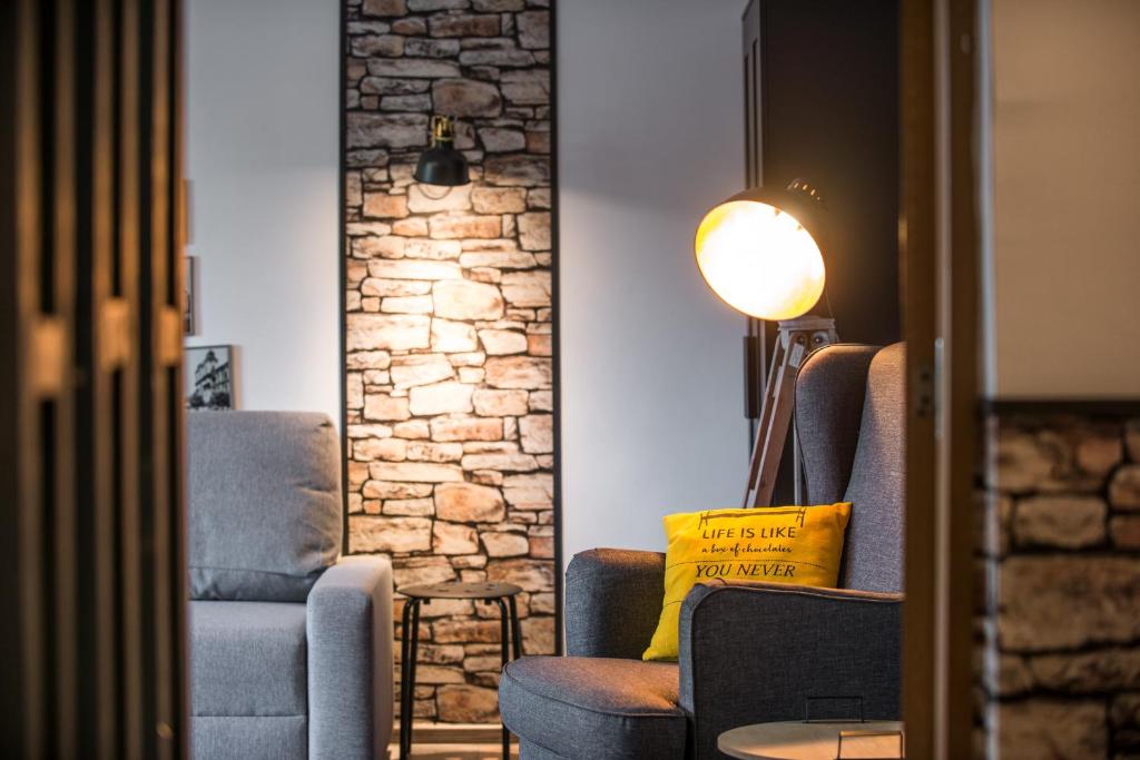 a living room with two chairs and a yellow pillow at Rent in Cluj Apartments in Cluj-Napoca