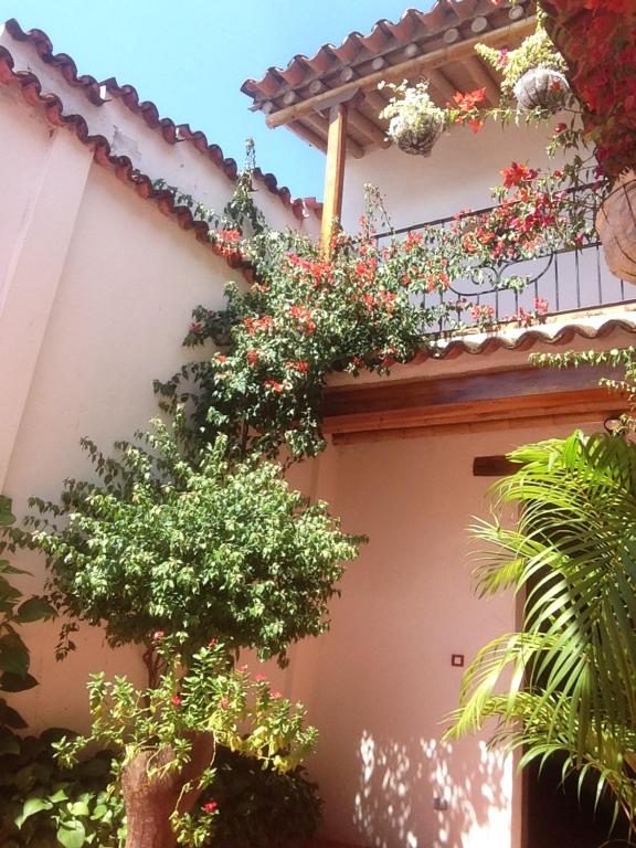 a building with flowering plants on the side of it at Casa Verde Albarrada in Mompos