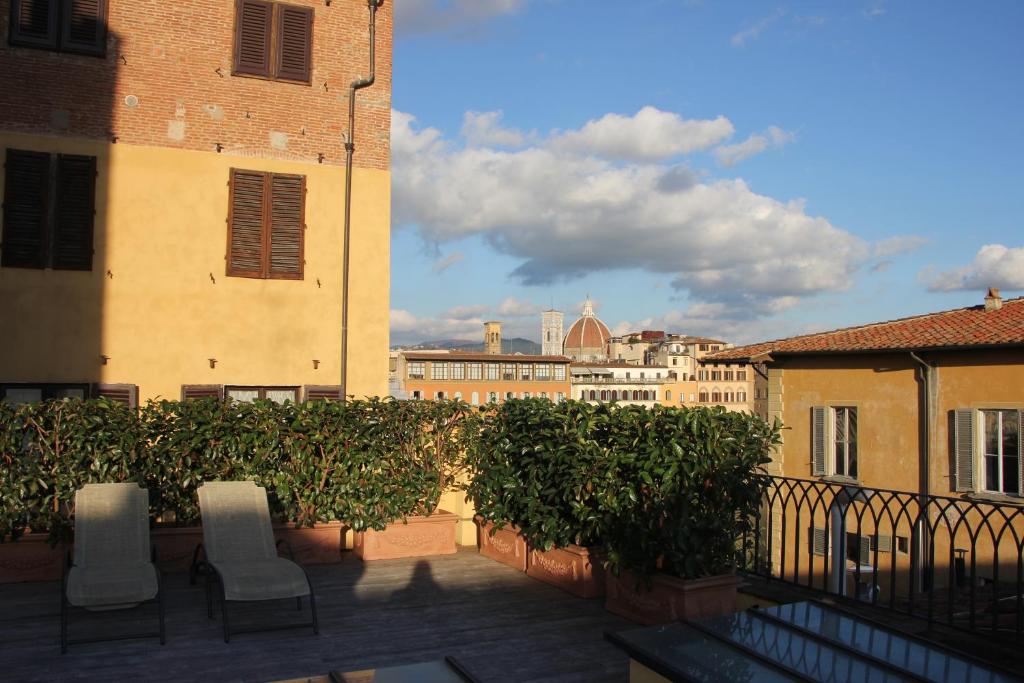 a balcony with chairs and a view of a city at Lanfredini Firenze in Florence