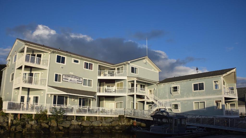 um grande edifício de apartamentos ao lado de um corpo de água em Longliner Lodge and Suites em Sitka