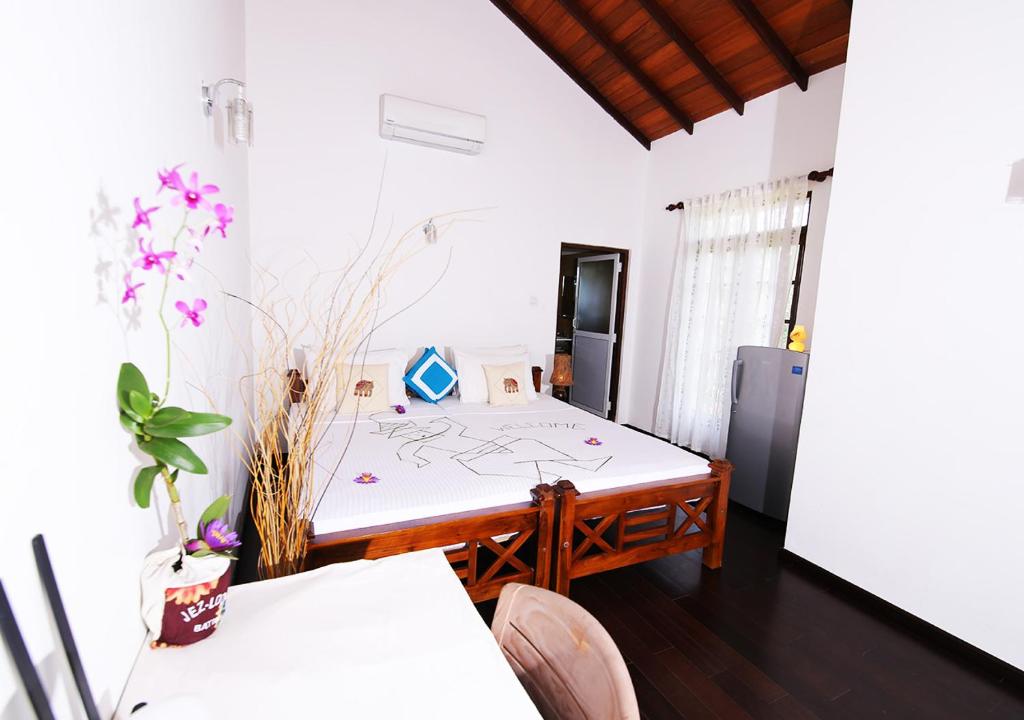 a room with a bed with a table and chairs at Lahiru Villa in Galle