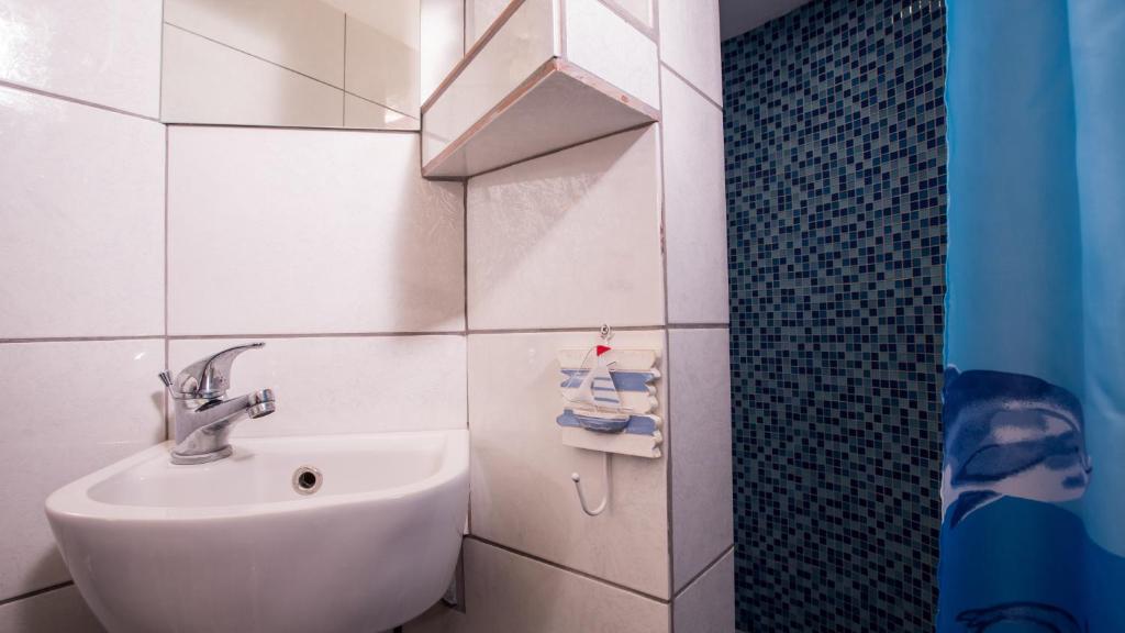a white bathroom with a sink and a shower at Petaluda House 1 in Athens