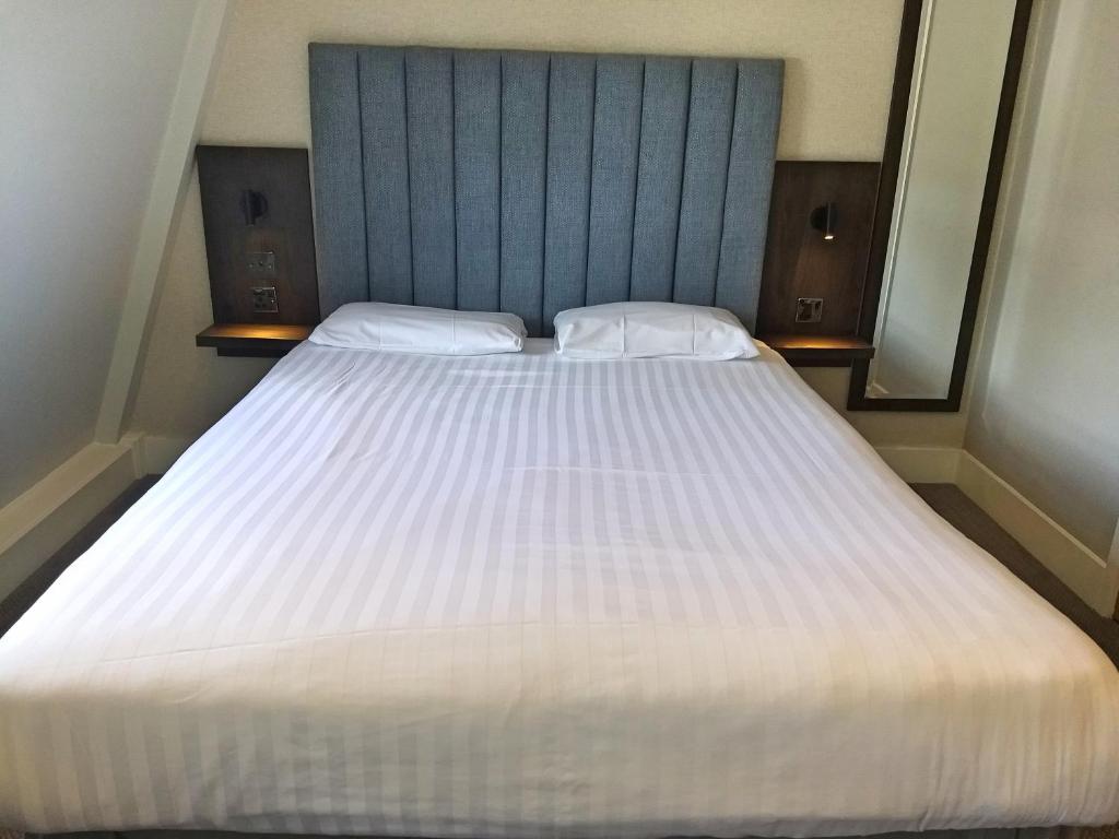 A bed or beds in a room at Garden Court Hotel