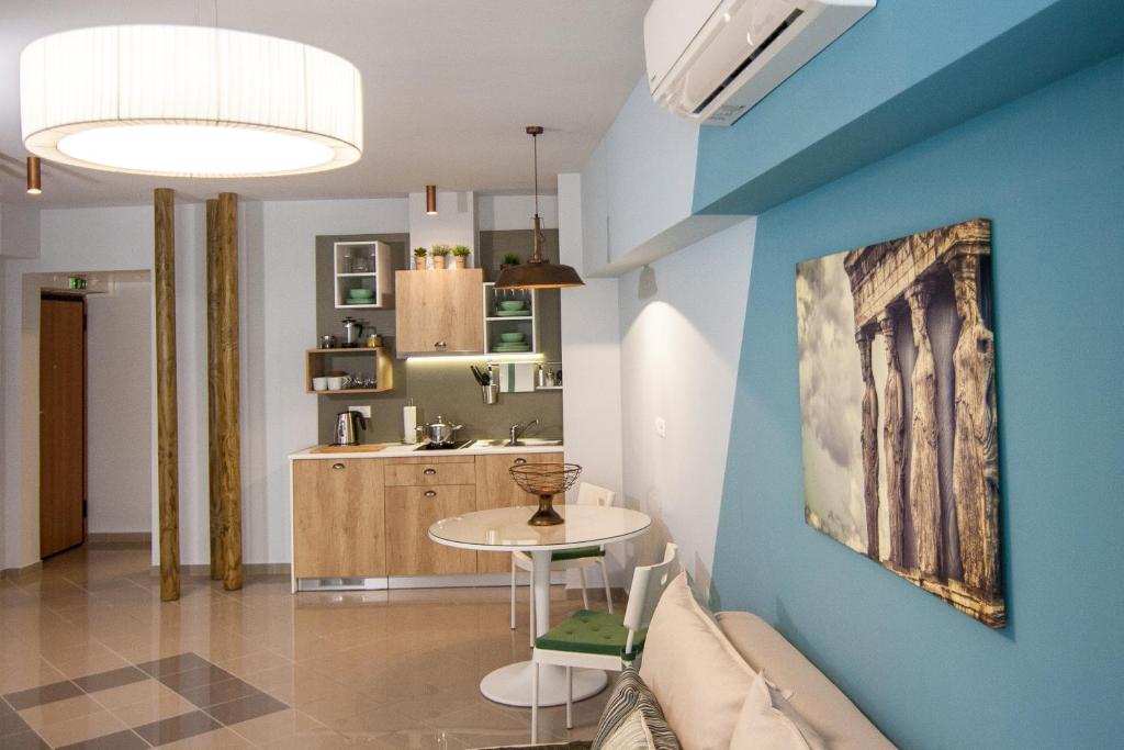 a living room with a table and a kitchen at Dynasta Central Suites in Athens