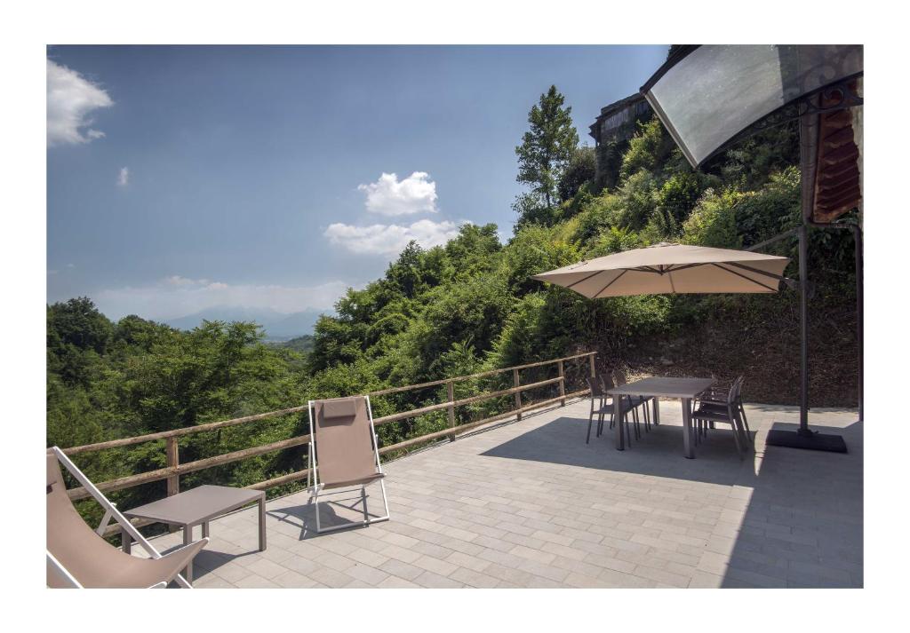 eine Terrasse mit einem Tisch und einem Sonnenschirm in der Unterkunft Il Borgo di Tresana Casa Marina in Tresana
