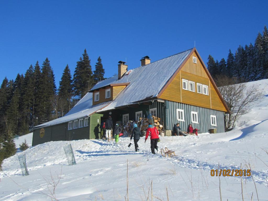 a group of people walking in the snow in front of a barn at Horská Chata U Básníka in Horní Malá Úpa