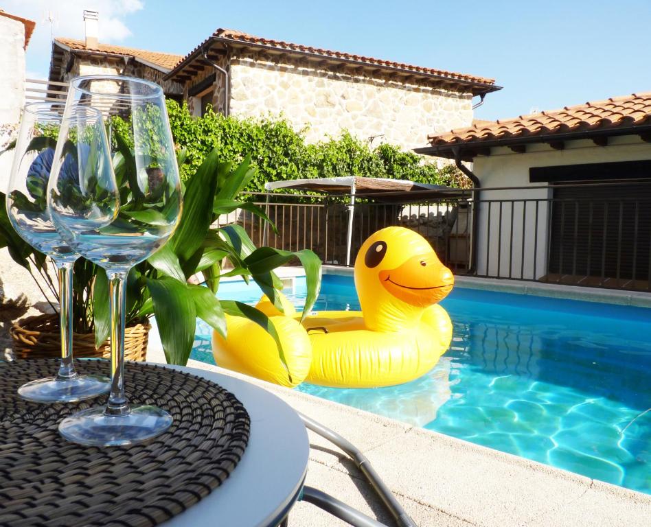 a table with a yellow rubber duck in a swimming pool at Casa Rural Cabeza Lobera in Villanueva de Ávila
